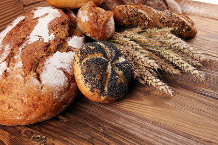 不同种类的面包和面包卷在船上从上面。厨房或烘焙海报设计