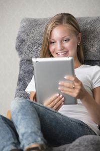 在 tablet pc 上阅读的年轻成年女性