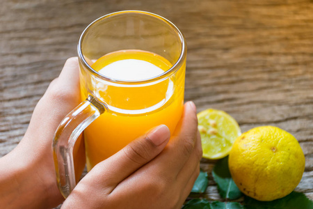 早餐区每天手捧着一杯橙汁喝在老木桌上, 每天早上新鲜的早餐, 橙色