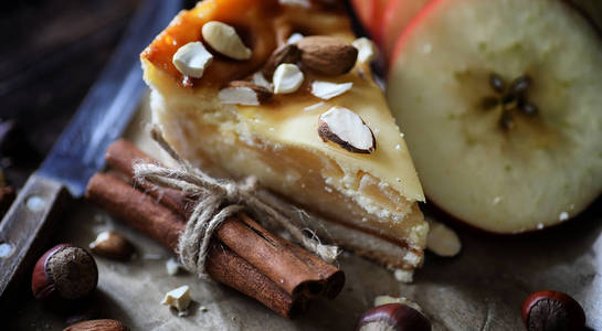在木桌上有肉桂和苹果的馅饼。新鲜糕点机智