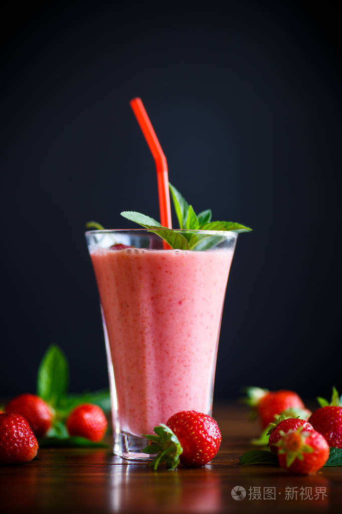 桌上的玻璃杯中的草莓鲜甜果汁