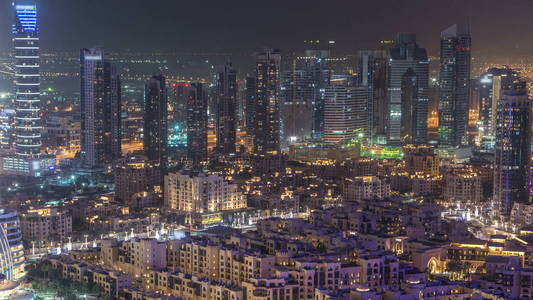 迪拜市中心夜 timelapse 与现代照明摩天大楼, 购物中心和交通的道路上。上方视图