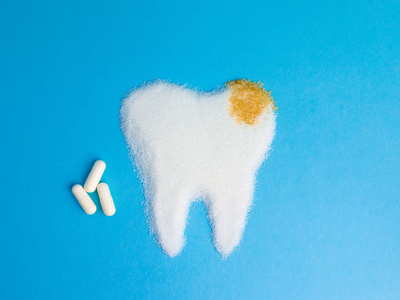 牙齿从白色和鲍恩糖与 pils 在蓝色背景, 标志