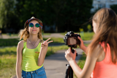 两个穿着鲜艳 t恤衫的女孩。夏天在自然。快乐的微笑的太阳镜在帽子。在城市记录视频。街头采访的概念