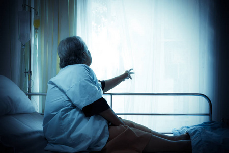 老年女性独自坐着, 在医院里等待着孤独的心情和色调颜色的病床病人