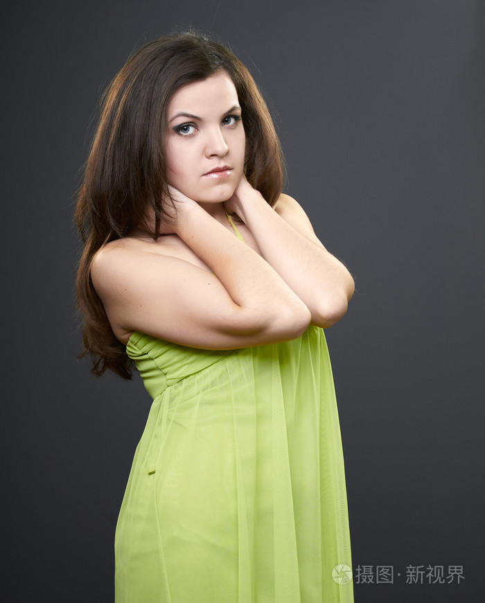 有魅力的年轻女人在一条绿色连衣裙.女人抱着她的脖子