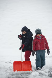 年轻孩子们铲掉人行道上的雪