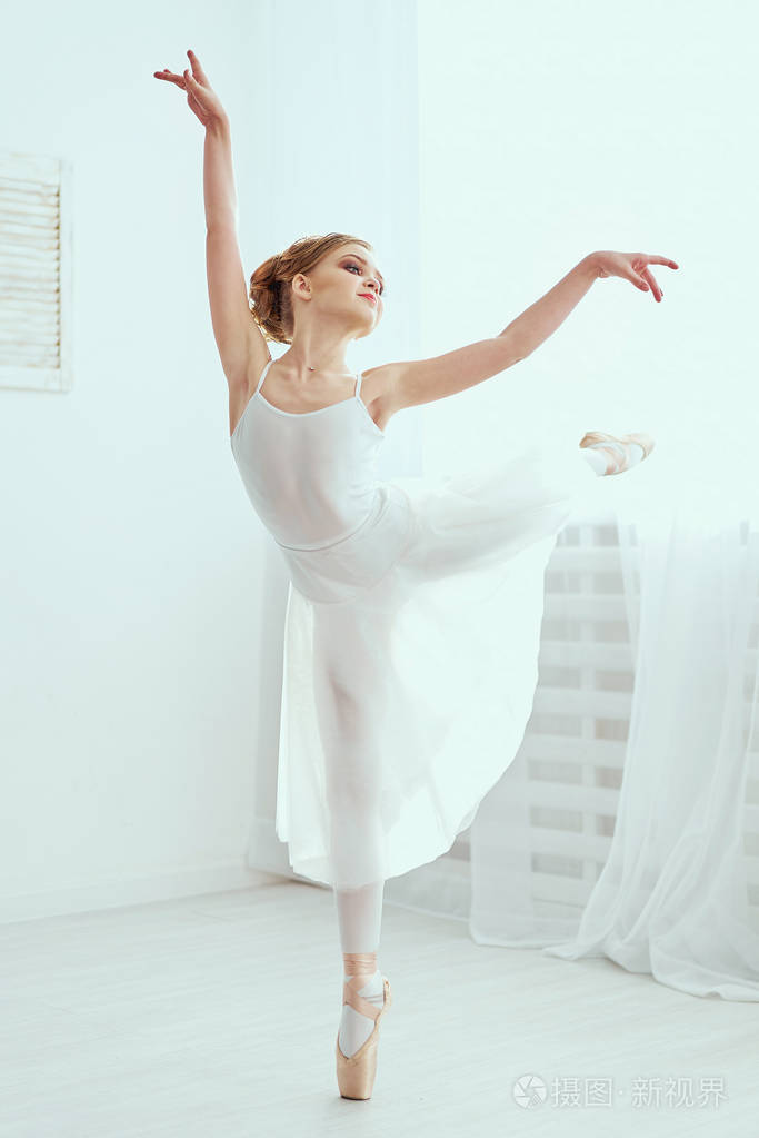 那个漂亮的女孩在训练厅里从事芭蕾舞.