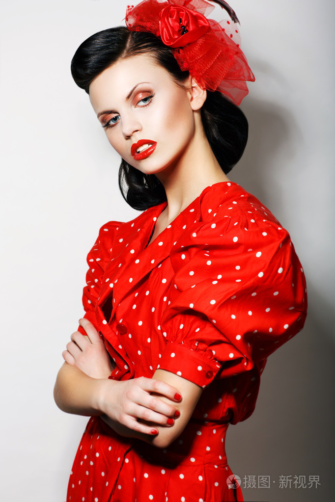 老练的傲慢女人的红色圆点连衣裙交叉的武器.时尚.复古风格-针