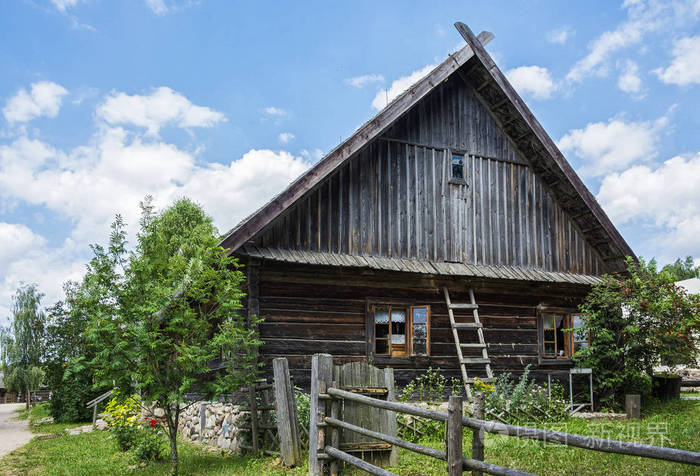 乡村建筑。老村庄日志小屋和围场在篱芭之后