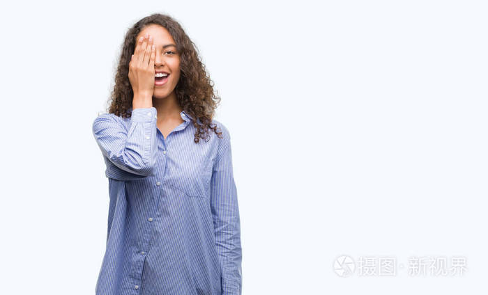 年轻的西班牙商界妇女用手捂着一只眼睛脸上充满自信的笑容和惊喜的