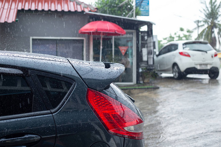 洗完车后, 雨点落在深蓝色的汽车上