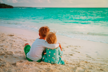 小男孩和女孩拥抱在海滩假期