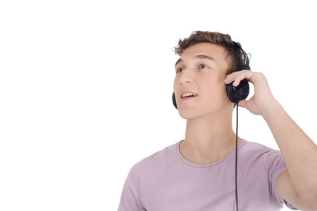 微笑的青少年听音乐的肖像与耳机。孤立的白色背景