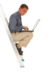 男子坐上梯子在笔记本电脑上工作