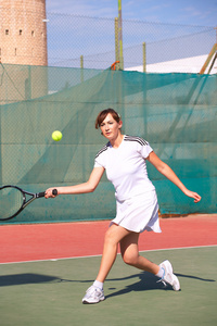 年轻的女人在打网球