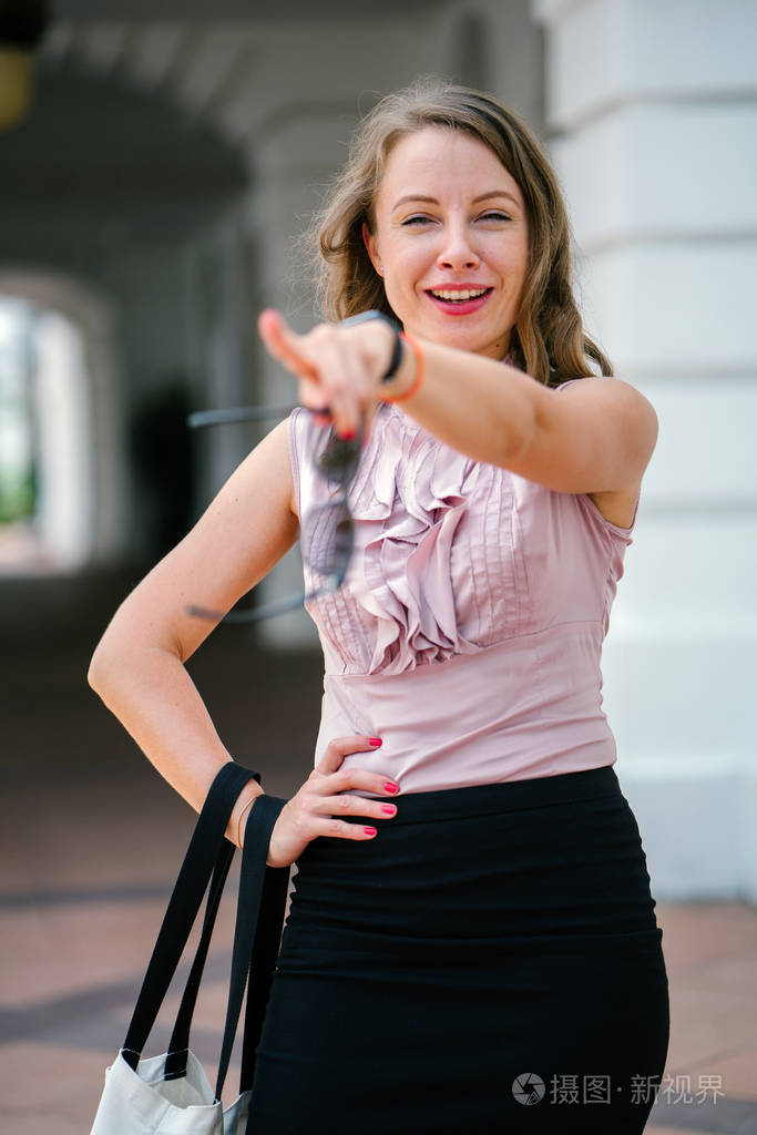在城市中假扮白人白种女人的画像.她穿着专业的办公服装和微笑.