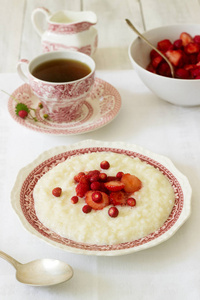配有茶的草莓调味粥的实用早餐