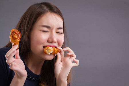 女人吃不健康的脂肪炸鸡不健康的女孩的肖像吃脂肪炸鸡, 快餐不健康饮食, 高胆固醇脂肪饮食概念亚洲华人20s 女模特