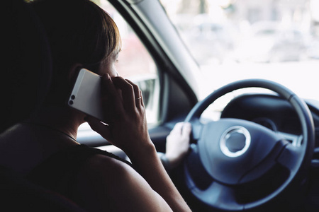 车上的女人在开车时用手机说话