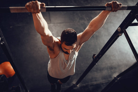 强壮的年轻肌肉男在健身房做拉运动