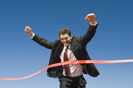 越过终点线的商人照片