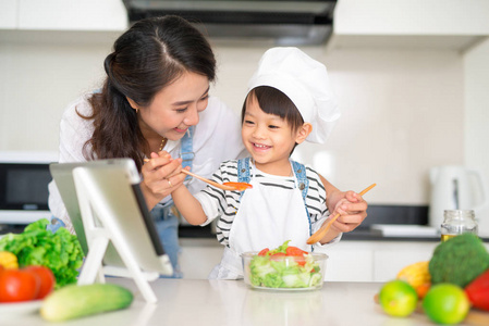 母亲与女儿在厨房里准备午餐, 一起享受