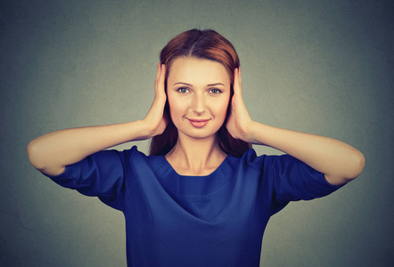 年轻谣言聪明的年轻妇女捂着耳朵不愿听到谣言和愚蠢的事情照片