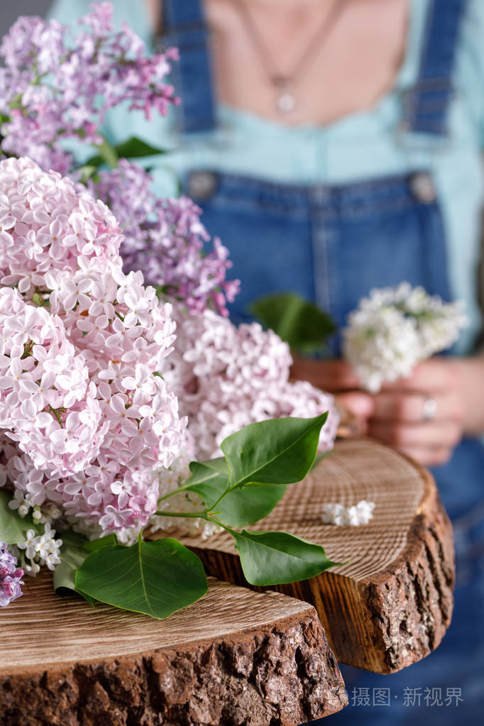 一束柔和的丁香花在木质的伤口上着色背景工作服图