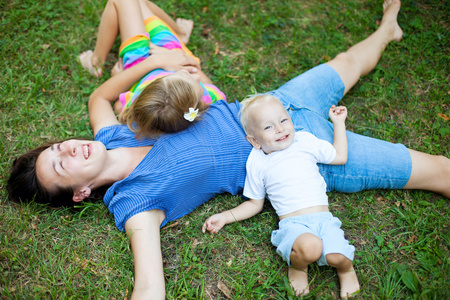 快乐家庭享受自己躺在草地上图片