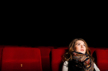 年轻有魅力的女人坐在一家电影院