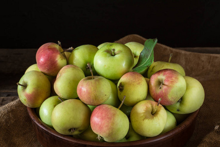 成熟的红色和绿色的苹果在木质背景。苹果在碗里。花园水果。秋天的果子。秋季收获