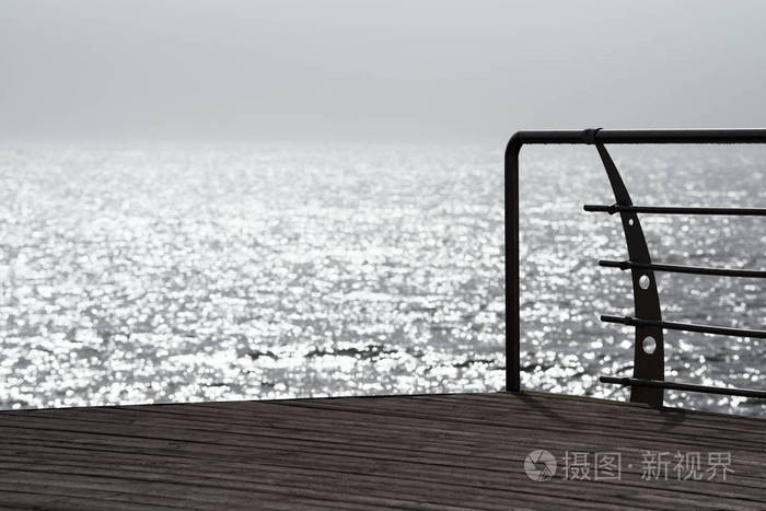 早晨海岸风景。海水中的太阳眩光。晨雾