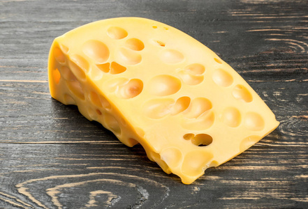木制背景上有孔的奶酪片