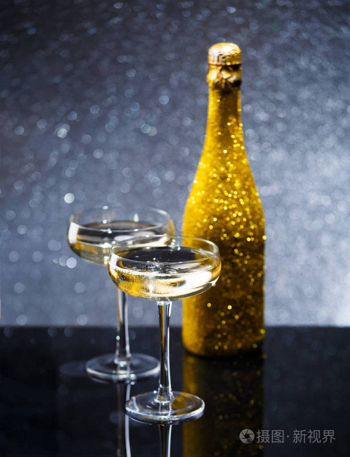 黑桌上的酒瓶和两杯酒杯的图片