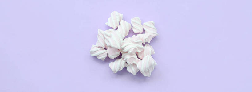 彩色棉花糖奠定了紫色纸的背景。柔和的创意质感。最小