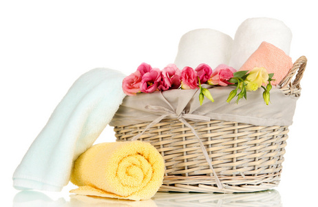 浴室的毛巾折叠在柳条篮上白色隔离