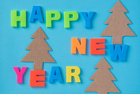 新年快乐文本与塑料信件在蓝色纸背景