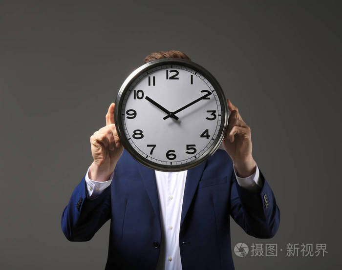 在黑暗背景下的钟表商人.时间管理概念