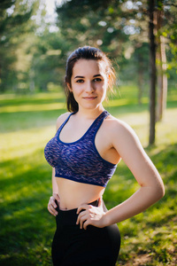 公园里的一个漂亮女孩从事体育运动。一种具有清洁皮肤和 oboyatelnoy ulvbkoy 的运动服装模型。露天培训