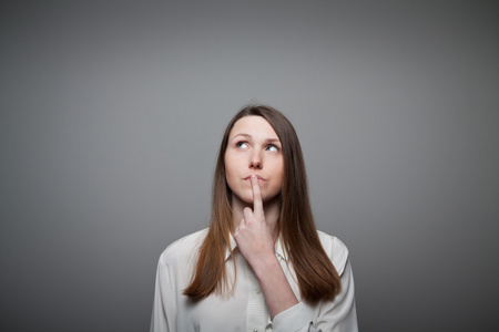 犹豫年轻的焦虑的犹豫不决的紧张的女人咬她的指甲质疑商家犹豫不决