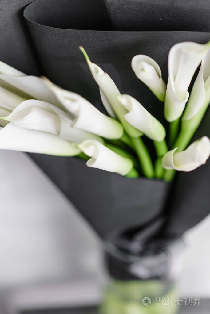 黑色纸盖玻璃花瓶中美丽的白色马蹄莲百合花