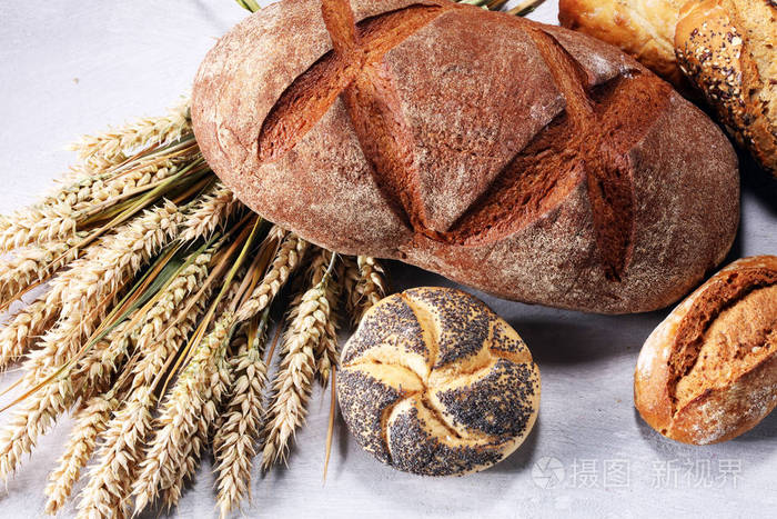 不同种类的面包和面包卷在船上从上面。厨房或烘焙海报设计
