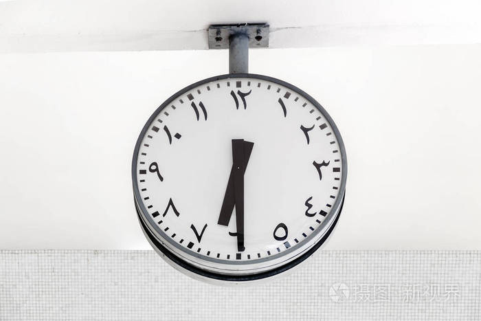 现代时钟圆形状以阿拉伯语通知在表盘和手, 显示时间 6:30