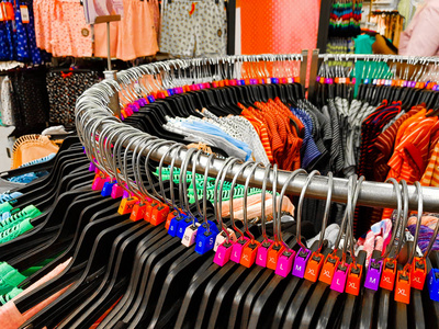 不同大小的衣架与五颜六色的礼服大小标签 Xl L M 吨衬衫显示在商店出售