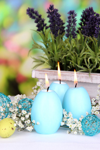 复活节蜡烛与鲜花在明亮的背景上