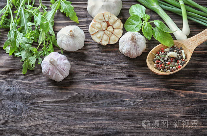 在木质背景下用新鲜大蒜大葱和香料组成