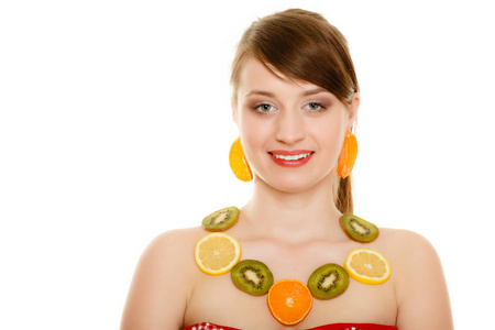 饮食。快乐的女孩项链和耳环上白色孤立的新鲜柑橘类水果。推荐的健康食品和营养的年轻女子