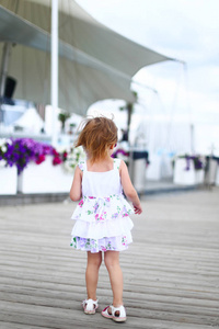 小女孩穿着连衣裙在夏天独自行走