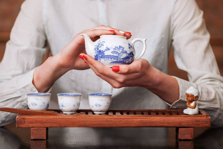手持枪镜头前女子手持瓷茶壶照片